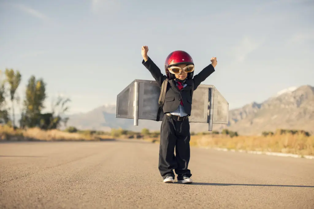Young Boy Wearing Business Suit and Jet Pack Flies